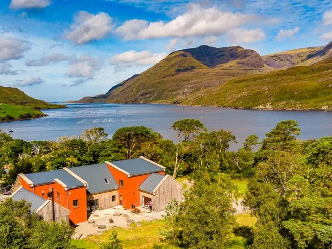 a wooden building by a lake on a sunny day in Connemara