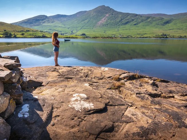 a woman standing by a lake in Connemara